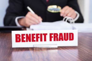 Unemployment insurance benefits fraud agent reviewing official benefits paperwork